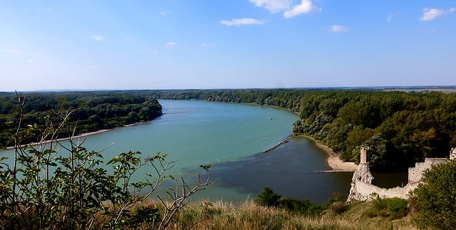 Foto på ett grönt landskap som domineras av det klarblå vattnet i floden Donau i Tyskland.